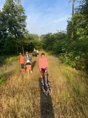 a group of people walking a dog on a trail at B&B Crijbohoeve in Zutendaal
