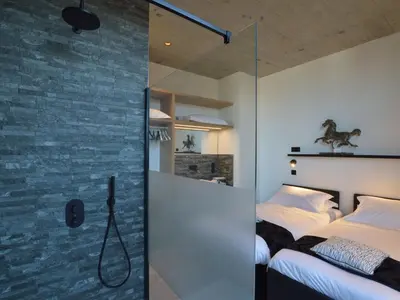 a bedroom with a bed and a glass shower at Modern Dalhem Villa with Views in Dalhem