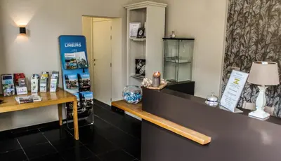 a room with a counter with a table with a lamp at Hotel De Maretak in Dilsen-Stokkem
