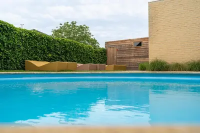 a swimming pool in front of a building at Hotel De Maretak in Dilsen-Stokkem