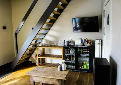 a room with a staircase and a shelf with drinks at Hotel De Maretak in Dilsen-Stokkem