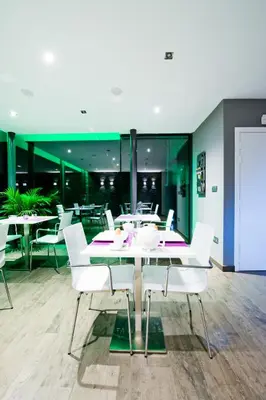 a dining room with white chairs and a table at B&B Villa Curtricias in Kortessem