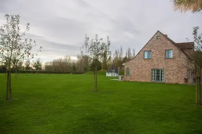 a brick house in a green field with trees at 'Op de Borgt' met Finse Grill Kota in Wellen