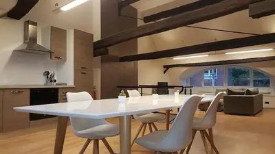 a white dining table and chairs in a kitchen at The Mind Box in Liège