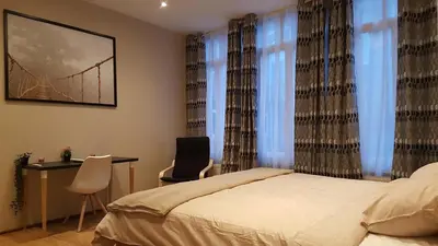 a bedroom with a bed and a desk and chairs at The Mind Box in Liège