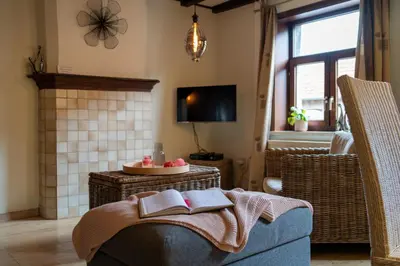 a living room with a couch with a book on it at De Mandenvlechter in Dilsen-Stokkem