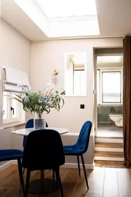a dining room with a table and blue chairs at Maas Suites (Maastricht - Lanaken) in Lanaken