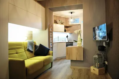 a living room with a yellow couch and a kitchen at 33 Paveestraße in Eupen