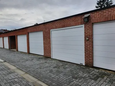 a row of four garage doors on a brick building at Stadshuisje 36 in Hasselt