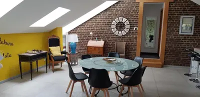 a room with a table and chairs and a brick wall at LA BINAMERIE in Remicourt