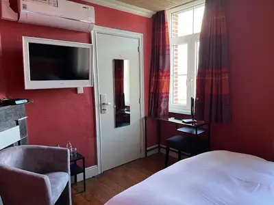 a hotel room with a bed and a tv on the wall at Gasthof De Statie in Wilderen