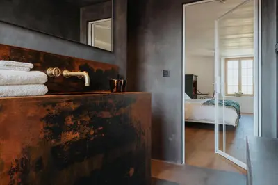 a bedroom with a bed and a sink and a mirror at Amitié in Kinrooi