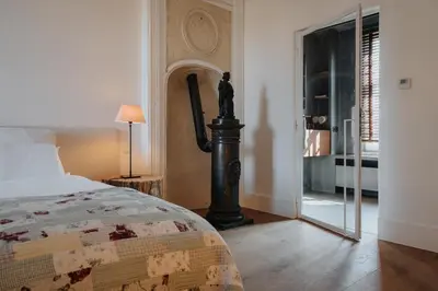 a bedroom with a bed and a door with a window at Amitié in Kinrooi