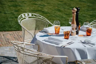 a table with a white tablecloth and chairs with wine glasses at Amitié in Kinrooi