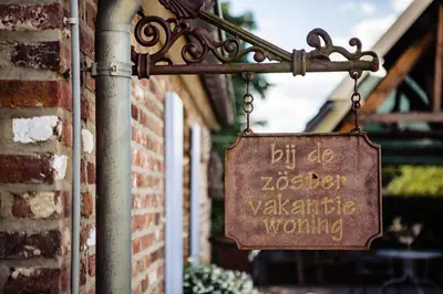 a sign hanging from the side of a brick building at Bij de Zöster in Kinrooi
