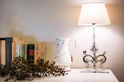 a lamp and a vase on a table next to books at Bij de Zöster in Kinrooi