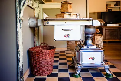 a kitchen with a checkered floor with an old fashioned espresso machine at Bij de Zöster in Kinrooi