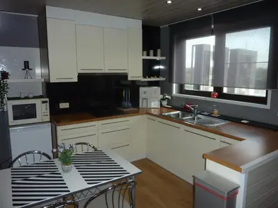 a kitchen with white cabinets and a table and a sink at Vakantie woning De Loft in Dilsen-Stokkem