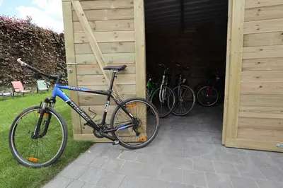 a bike parked in a garage next to two bikes at De Lokroep in Heers