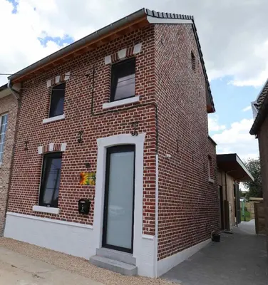 a brick building with a door on the side at De Lokroep in Heers