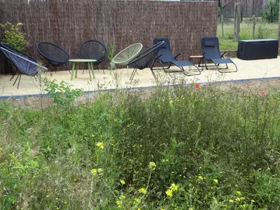 a group of chairs and tables in a garden at De Lokroep in Heers