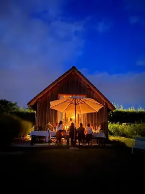 a group of people sitting at a table under an umbrella at Boerderaaj vakantiewoning in Bilzen