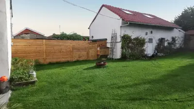 a yard with a fence and a white house at Spacious House in Tongeren in Tongeren