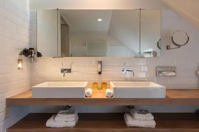 a bathroom with two sinks and a large mirror at Hotel De Barrier in Houthalen-Helchteren