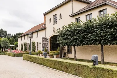 a large building with plants in front of it at Hotel De Barrier in Houthalen-Helchteren
