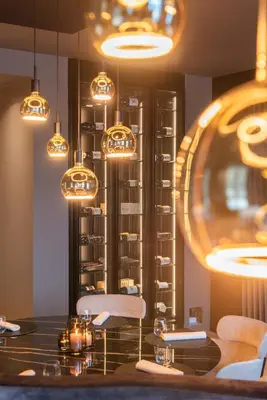 a dining room with a table and chairs and lights at Hotel De Barrier in Houthalen-Helchteren