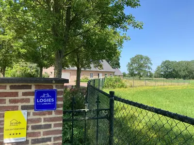 a sign on a fence in front of a field at Vakantiewoning Pelterheggen in Grote Heide