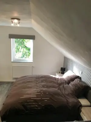 a bedroom with a bed and a window at Bij de lindeboom in Maaseik