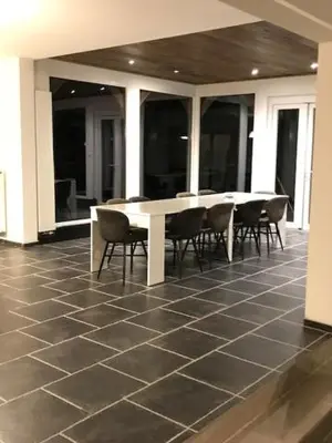 a room with a table and chairs on a tiled floor at Bij de lindeboom in Maaseik