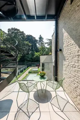 a patio with a table and chairs on a balcony at BareFoodGIULIA - Inspiration Hotel in Hasselt