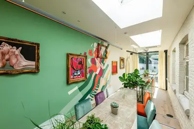 a dining room with a green wall with a table and chairs at BareFoodGIULIA - Inspiration Hotel in Hasselt