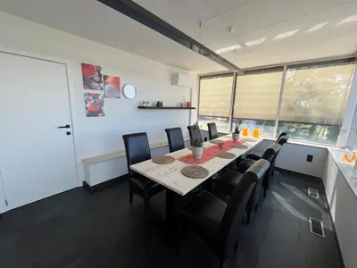 a dining room with a long table and chairs at GT Lounge in Heusden - Zolder