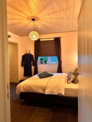 a bedroom with a large bed with a ceiling at ‘t Vaerthuys in Dilsen-Stokkem