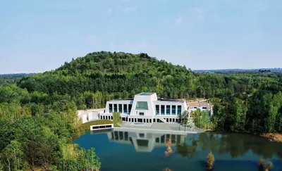 an aerial view of a house on top of a lake at ‘t Vaerthuys in Dilsen-Stokkem