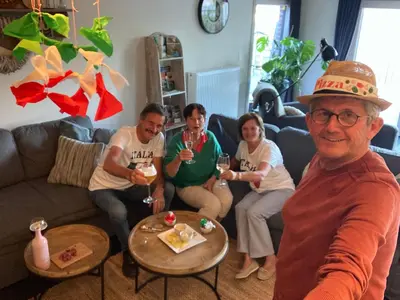 a group of people sitting in a living room drinking wine at ‘t Vaerthuys in Dilsen-Stokkem