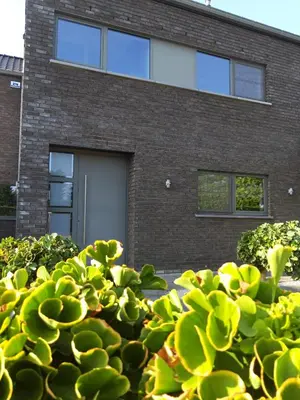 a bush in front of a building with a garage at La Maison de Marie in Borgloon