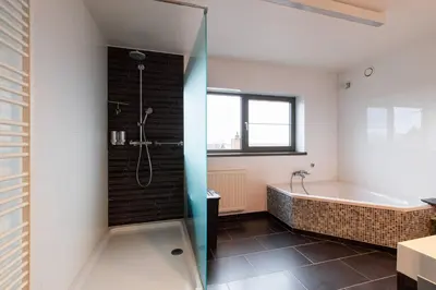 a bathroom with a bath tub and a shower at La Maison de Marie in Borgloon