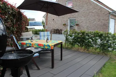 a table and chairs with an umbrella on a patio at Éco Gîtes Aubelrando & villa-bocage in Aubel