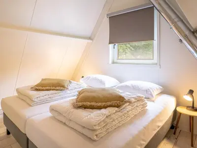 a bedroom with two beds with pillows and a window at Boshuisje Rekem - Luka in Lanaken