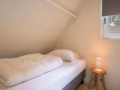 a small bed in a room with a window at Boshuisje Rekem - Luka in Lanaken