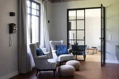 a living room with two chairs and a mirror at De Sjieper in Lanaken