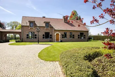 a large brick house with a driveway at De Sjieper in Lanaken