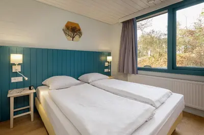 a bedroom with a large bed and a window at Center Parcs Erperheide in Peer