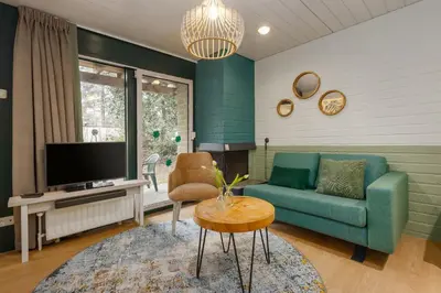 a living room with a couch and a tv at Center Parcs Erperheide in Peer