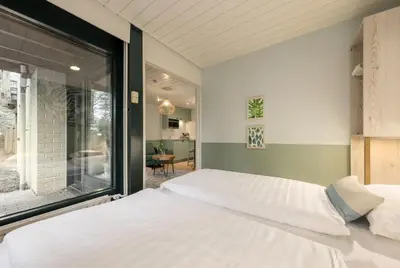 a bedroom with a bed and a large window at Center Parcs Erperheide in Peer