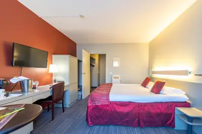 a hotel room with a bed and a desk at Hotel Ambiotel in Tongeren